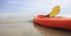 A bright orange kayak at the beach.