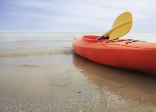 A bright orange kayak at the beach.